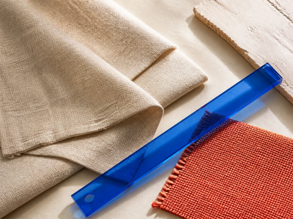 Natural linen, coral textile, and a blue acrylic ruler